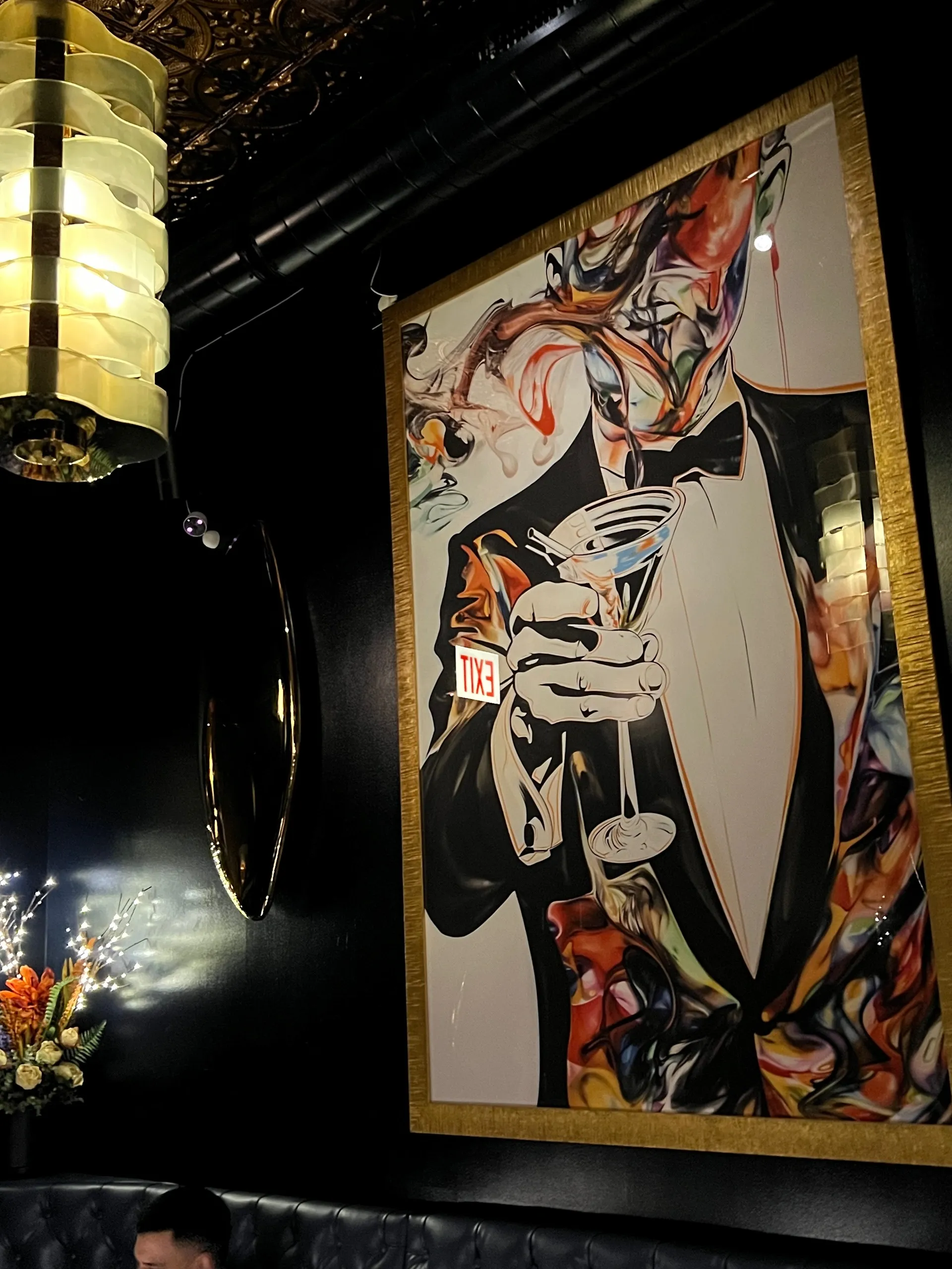 Framed painting of a tuxedoed figure holding a martini inside Wil's