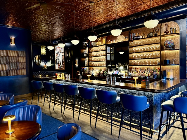 The full bar at Wil's with blue leather stools under a copper tin ceiling